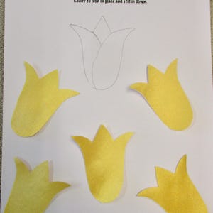May include: Five yellow felt tulip appliques, ready to iron and stitch down. The appliques are 3 inches in size.