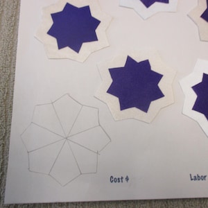 May include: A white paper template with a gray outline of a 10-pointed star. Four white paper shapes with purple star cutouts are arranged around the template. The text "Cost $" and "Labor $" is printed at the bottom of the page.