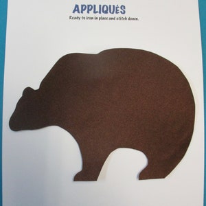 May include: Brown felt applique of a bear, ready to iron on and stitch down. The applique is 7.75 inches tall.