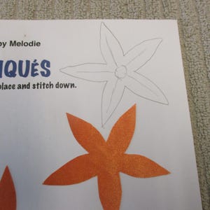 May include: A craft project with instructions for making appliques. The image shows a white outline of a five-pointed star and a five-pointed orange star.