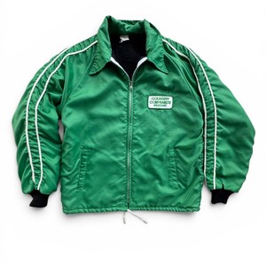 May include: A green zip-up jacket with white stripes down the sleeves and a black collar and cuffs. The jacket has a small patch on the chest that reads "COUNTRY COMPANIES INSURANCE".