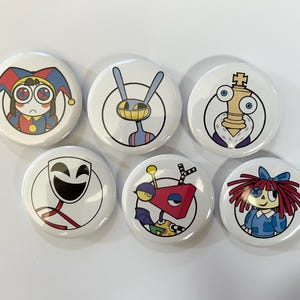 Pode incluir: Um conjunto de seis botões redondos com ilustrações coloridas de personagens de desenhos animados. Os designs incluem um bobo da corte, um coelho, uma peça de xadrez, uma máscara sorridente, uma figura robótica geométrica e uma boneca ruiva.
