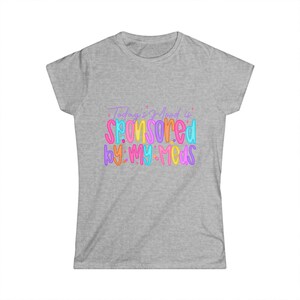May include: A light gray t-shirt with the text "Today's Mood is Sponsored by: My Meds" in colorful, bubble letters. The text is in shades of pink, orange, blue, and purple. The shirt is a crew neck style.