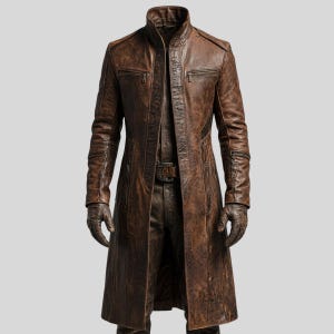 Puede incluir: Un abrigo largo de cuero marrón con cuello alto y múltiples bolsillos con cremallera. El abrigo tiene un acabado envejecido, lo que le da un aspecto vintage. Las mangas son largas y el abrigo parece estar bien hecho.