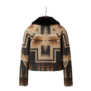 May include: A jacket featuring a black faux fur collar and a geometric pattern in shades of tan, brown, and charcoal gray. The garment has long sleeves and a straight hem, displaying a symmetrical design across the back and sleeves.