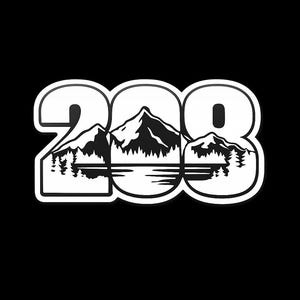 May include: White sticker with the number "208" in a bold, rounded font. The zero is replaced with a mountain range scene, featuring a lake and trees, all in black and white, set against a black background.