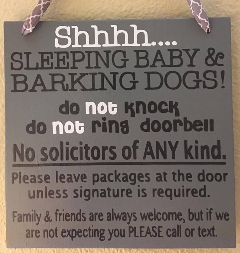 May include: A gray wooden sign with white and black text. The sign reads "Shhhh.... SLEEPING BABY & BARKING DOGS! do not knock do not ring doorbell No solicitors of ANY kind." It also includes instructions for package delivery and a welcome message for family and friends.