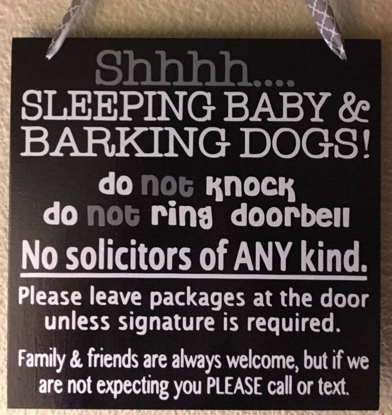 May include: Black square sign with white text that reads "Shhhh.... SLEEPING BABY & BARKING DOGS! do not knock do not ring doorbell No solicitors of ANY kind." It also says to leave packages at the door and to call or text if not expected.