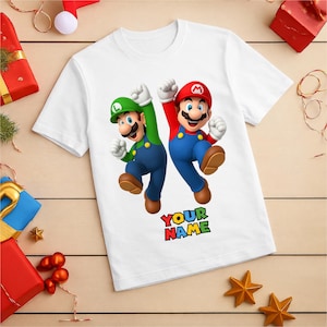 May include: White t-shirt with a graphic of Mario and Luigi, with the text "YOUR NAME". The cartoon characters are in their signature outfits, Mario in red and Luigi in green. The design is in a rainbow font.