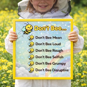 May include: A yellow-framed sign with the words "Don't Bee..." and a list of negative behaviours, each prefaced by "Don't Bee". The sign features cartoon bees and a rainbow. The sign is held by a person wearing a beekeeping suit.