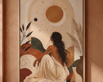 May include: A framed wall art print featuring a person with long dark hair sitting in a white draped garment. The scene includes a large sun, arched architectural elements, abstract shapes in terracotta and green, and dried pampas grass.