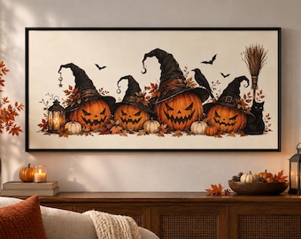 May include: A rectangular wall art print featuring four carved orange pumpkins wearing black witch hats, surrounded by autumn leaves, a lit lantern, a black crow, a broomstick, and a black cat, all set against a light cream-colored background.