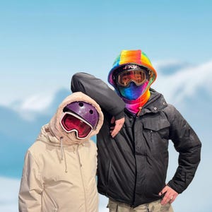 Könnte beinhalten: Zwei Personen mit Skibrillen und Kapuzenjacken. Eine Person trägt eine schwarze Jacke, eine Camouflage-Hose und einen Regenbogenhelm. Die andere Person trägt eine beige Jacke und einen lila Helm. Der Hintergrund ist ein blauer Himmel mit Wolken.
