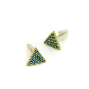 May include: A pair of gold triangle stud earrings with blue turquoise stones.