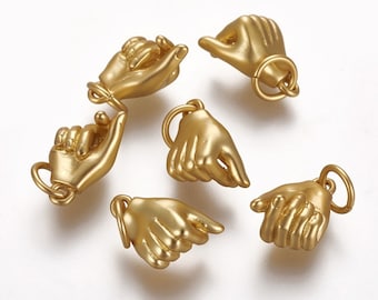 May include: Six gold-tone metal charms shaped like hands, each with a different gesture. The charms have a loop at the top for attaching to a bracelet or necklace.