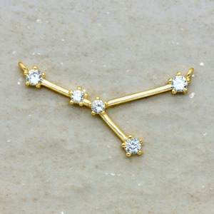May include: Gold-tone necklace with a constellation design featuring five clear cubic zirconia stones.