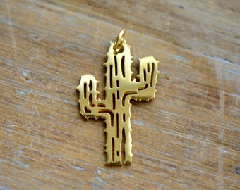May include: A gold-colored metal cactus charm with a detailed design. The charm is shaped like a cactus with multiple arms and a textured surface.