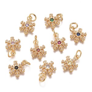 May include: Assortment of gold snowflake charms with various colored gemstones in the center. Each charm has a loop for attaching to jewelry.