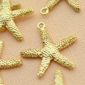 May include: Gold-toned metal starfish charms with a textured surface. The charms have a loop at the top for attaching to jewellery or other crafts.