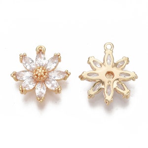 May include: A pair of gold-tone flower-shaped charms with clear crystal accents. The charms have a loop at the top for attaching to jewellery.