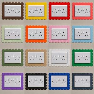May include: A collection of sixteen white double electrical wall socket covers, each framed by a decorative scalloped border in a different solid colour including brown, yellow, red, coral, light green, orange, pink, blue, olive, tan, white, green, purple, black, royal blue, and navy.