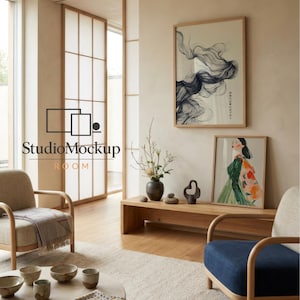 May include: A modern living room with neutral tones, featuring a wooden coffee table, two armchairs, and a blue upholstered chair. Artwork and decorative items adorn the walls and table. The room has a minimalist design with natural light.