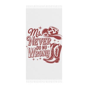 May include: White rectangular towel with a fringed edge, featuring a maroon graphic of a cowboy hat, boots, and the text "Ms. Never Do No Wrong." The design is a vintage-style illustration.