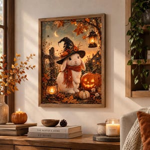 May include: A framed wall art print depicting a white rabbit wearing a black witch hat and a red scarf, standing in an autumn forest scene with a glowing jack-o'-lantern, fallen leaves, and two hanging lanterns under a crescent moon.