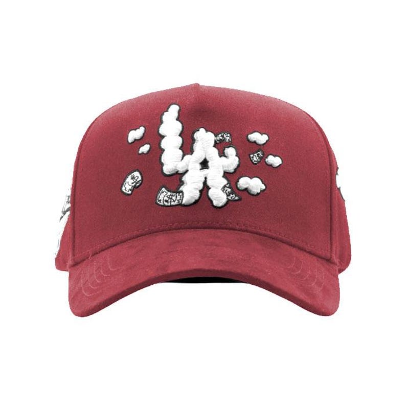 Peut inclure: Casquette de baseball bordeaux avec texte brod&eacute; blanc et motifs nuageux. Le texte semble &ecirc;tre "LA" dans une police stylis&eacute;e. La casquette a une visi&egrave;re incurv&eacute;e et une couronne structur&eacute;e.