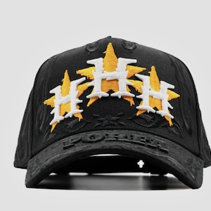 Puede incluir: Gorra de b&eacute;isbol negra con tres logotipos bordados en forma de estrella en amarillo y blanco. La gorra tiene una visera curva y un dise&ntilde;o texturizado. La palabra "FOREVER" est&aacute; grabada en la visera.