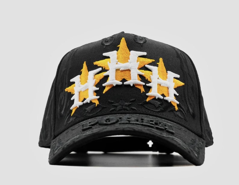 Puede incluir: Gorra de b&eacute;isbol negra con tres logotipos bordados en forma de estrella en amarillo y blanco. La gorra tiene una visera curva y un dise&ntilde;o texturizado. La palabra "FOREVER" est&aacute; grabada en la visera.