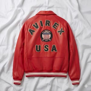 Peut inclure: Veste en cuir rouge avec le mot "AVIREX" en arc sur les &eacute;paules. En dessous, un &eacute;cusson avec les mots "ALL AMERICANS" et "ESTABLISHED 1975". Le mot "USA" est en dessous. La veste a une bordure ray&eacute;e blanche et rouge.