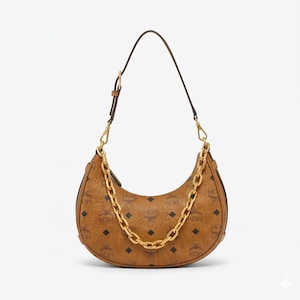 Pu&ograve; includere: Una borsa marrone a forma di mezzaluna con una catena dorata e un cinturino in pelle marrone. La borsa presenta un motivo con logo ripetuto. Una catena dorata &egrave; drappeggiata sulla parte anteriore della borsa.