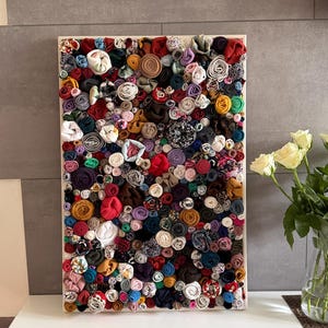 Könnte beinhalten: Ein Set aus drei Keramikbechern mit gesprenkelter, matter Oberfläche. Die Becher sind in Creme-, Hellgrau- und Dunkelgrautönen gehalten. Jeder Becher hat ein schlichtes, minimalistisches Design, ideal für Kaffee oder Tee.