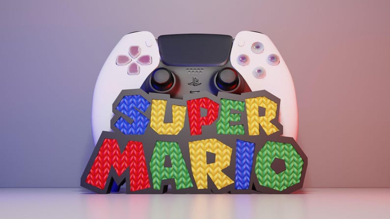 May include: A white and black game controller with the words "SUPER MARIO" in colorful, textured letters. The controller has pink and purple buttons. The background is a gradient of purple and red.
