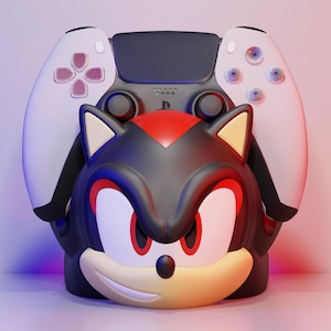 May include: A black, red, and tan Shadow the Hedgehog character design with a white and black game controller. The controller is positioned behind the character's head. The character has red eyes and a smiling expression.