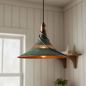 May include: A hanging pendant light with a conical shade. The shade has a distressed green finish with copper accents and a decorative copper wire wrap. The light fixture has a warm, inviting glow, perfect for kitchen or dining room lighting.