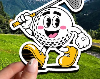 May include: A cartoon golf ball character with a smiling face, holding a golf club. The golf ball has black dimples, pink cheeks, and is wearing yellow shoes. The background shows a green golf course and mountains.