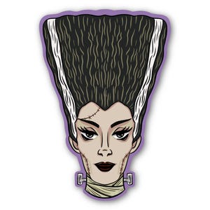 May include: A sticker featuring a stylized illustration of the Bride of Frankenstein. The image shows the Bride's face with black hair, white streaks, and stitched scars. She has dark lipstick and a neck bolt.