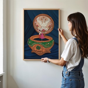 Woman hanging a framed Anastasia-inspired music box print on a white wall—romantic printable art for animation fans.