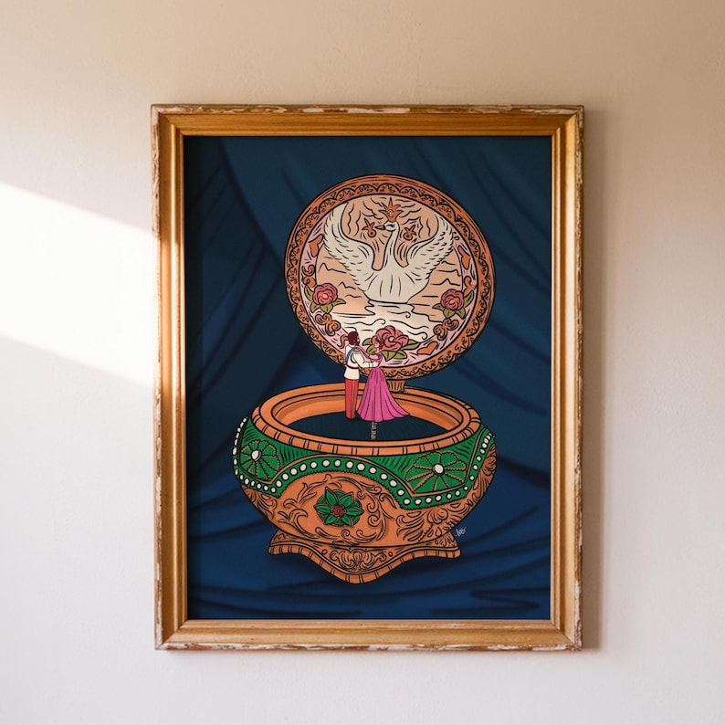 Framed artwork of a digital music box illustration featuring romantic dancers and swan detail, inspired by Together in Paris scene.
