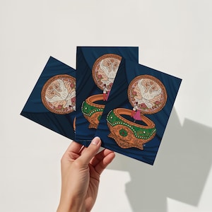 Hand holding three 5x7 art prints featuring an Anastasia-inspired music box digital illustration with romantic fairy-tale design.