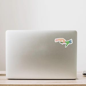 May include: A sticker of two hands reaching towards each other, one hand is green and the other is pink.