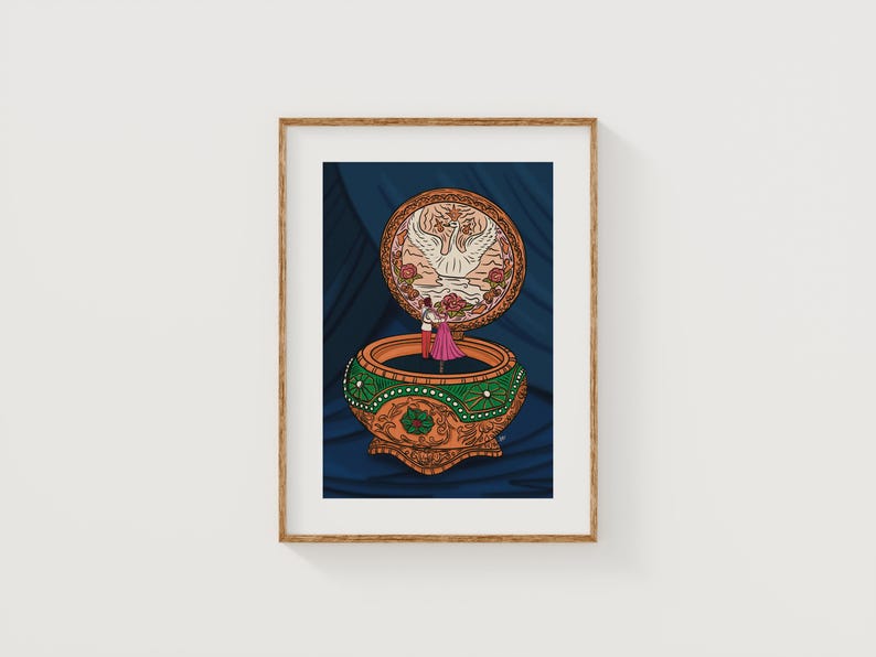 Framed Together in Paris art print displayed on a white wall, showcasing vintage music box illustration in cozy home decor style.