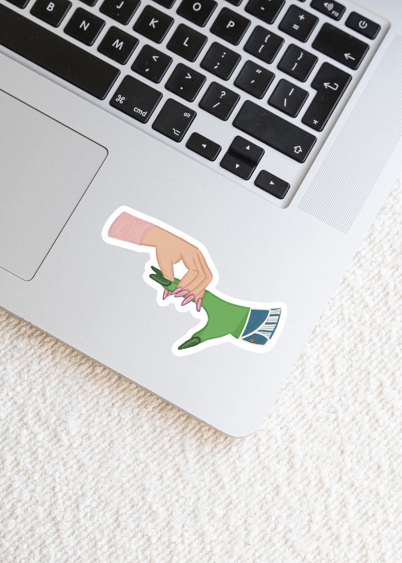 May include: A sticker featuring a green hand with blue denim and a pink hand with pink nails, both hands are reaching out to each other.