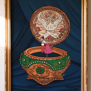 May include: A framed illustration of a music box with a swan and couple dancing. The box is orange and green with a detailed design. The background is a dark blue curtain.