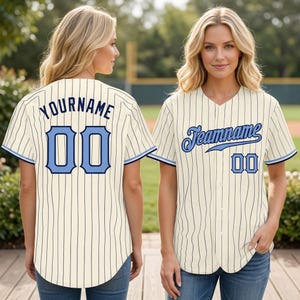 Puede incluir: Camiseta de béisbol color crema con finas rayas azul marino. La camiseta tiene una parte delantera abotonada, mangas cortas y un dobladillo redondeado. La camiseta tiene el texto "YOURNAME" y el número "00" en la espalda, y "Teamname" y "00" en la parte delantera.