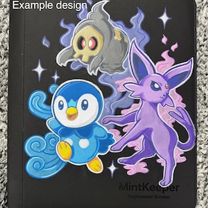 Puede incluir: Carpeta negra MintKeeper para toploader con ilustraciones de personajes de dibujos animados. El diseño incluye un pingüino azul, una criatura morada y una figura fantasmal. El texto "Example design" es visible.