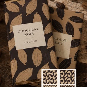 Peut inclure: Deux tablettes de chocolat rectangulaires enveloppées dans du papier avec un motif de cabosses de cacao. L'une est noire avec des cabosses beiges et une étiquette CHOCOLAT NOIR 70% CACAO. L'autre est beige avec des cabosses noires et une étiquette CHOCOLAT LAIT.