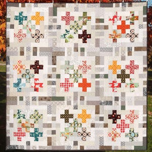 May include: A quilt with a patchwork design featuring a variety of colorful fabrics. The quilt is made up of squares and rectangles, and the colors include red, orange, yellow, green, blue, and brown. The quilt is displayed on a white background.